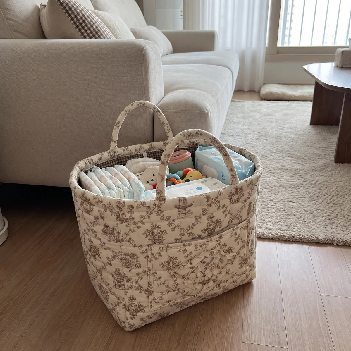 Quilted basket with diapers and wipes on a living room floor